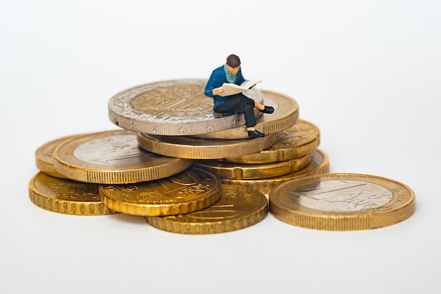 man sitting on giant coins reading the news on conveyancing costs