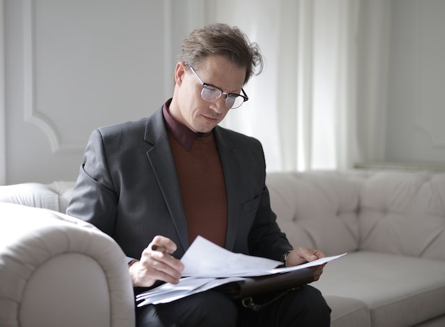 Business man looking at documents on sofa